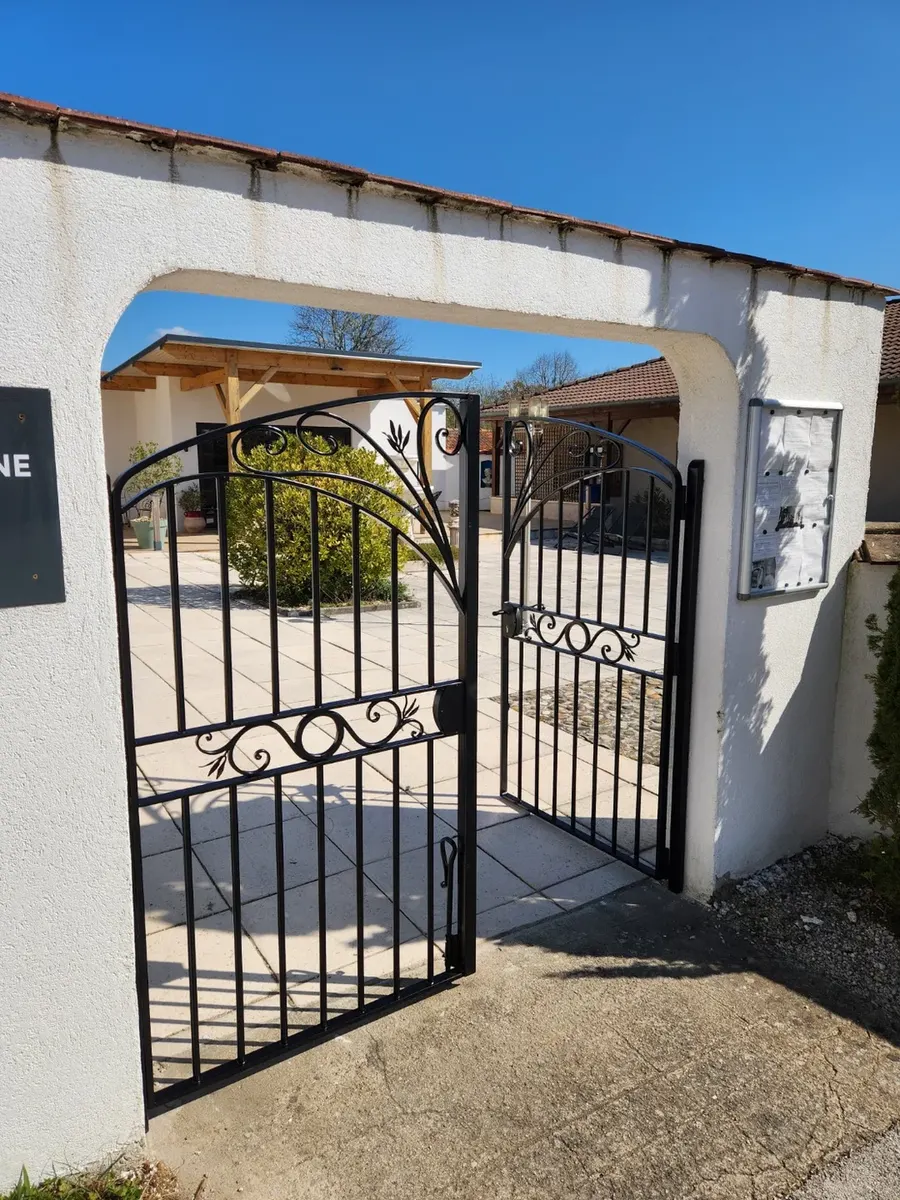 Portail d'art en fer forgé posé en cour pavée